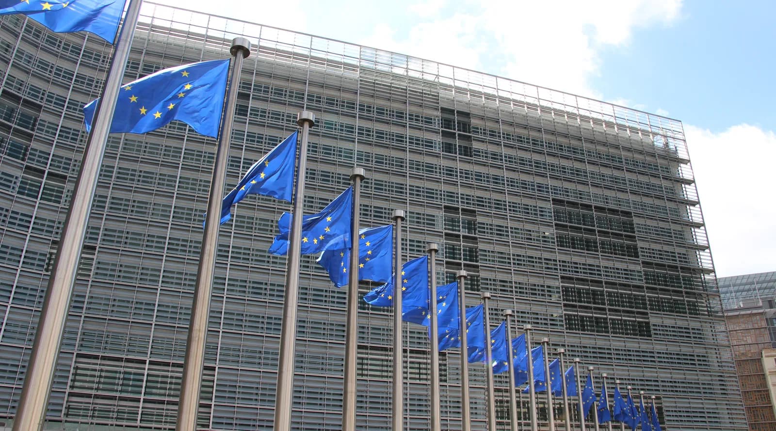 European Union flags in front of the Berlaymont building in Brussels.